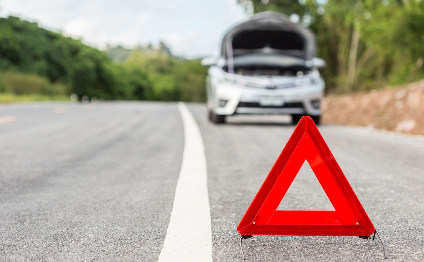 Warning triangle behind a broken-down car in Belle Glade, FL